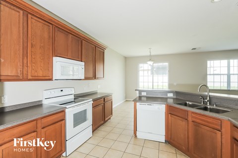 a large kitchen with white appliances and wooden cabinets