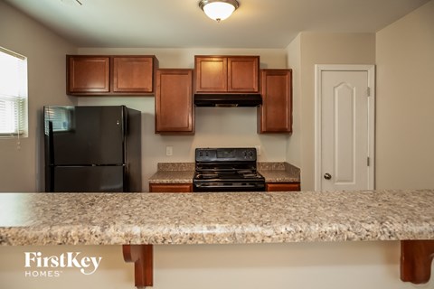 a kitchen with a granite counter top and a black refrigerator