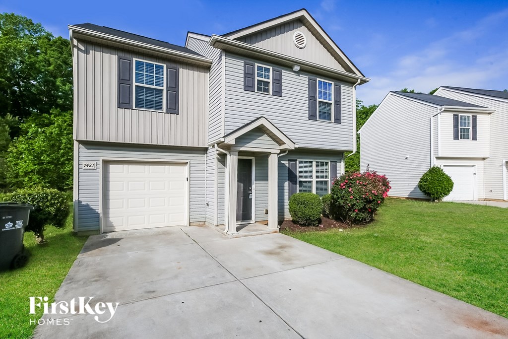 A two-story house with a garage is for sale.