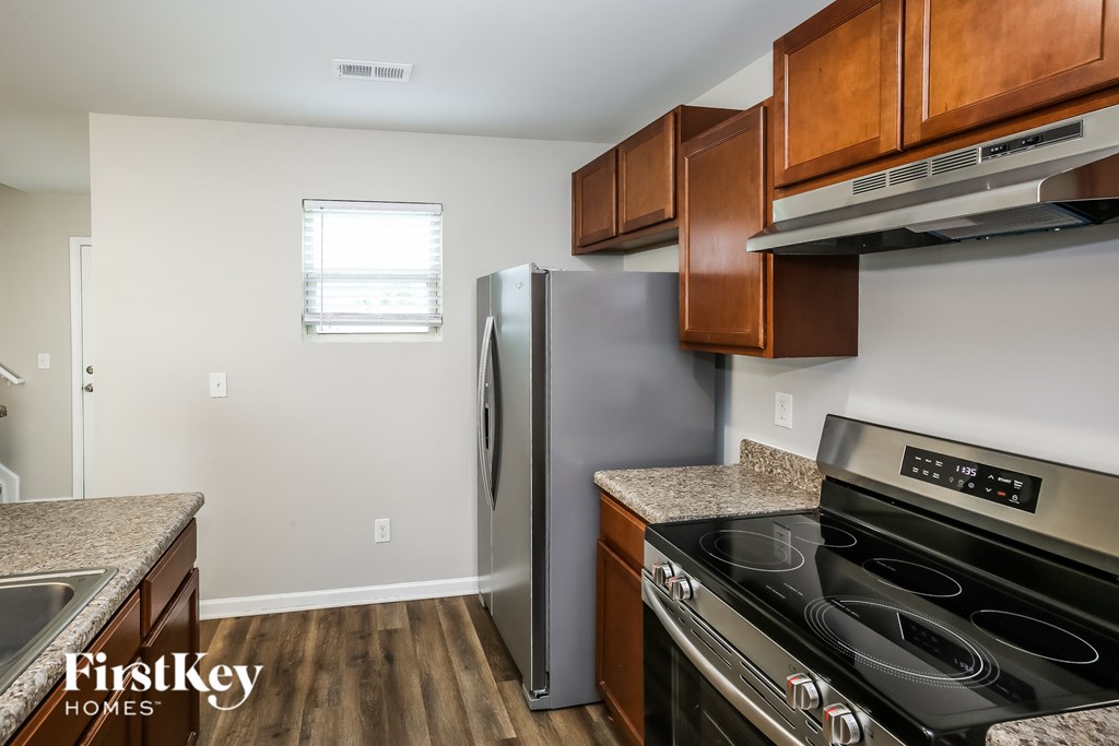 A kitchen with a stove top oven and a refrigerator.