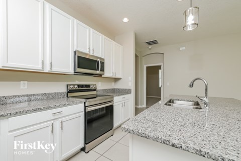 a kitchen with granite counter tops and white cabinets