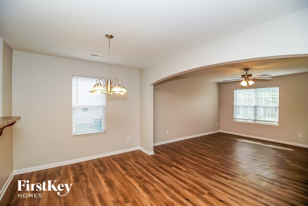 A room with wooden floors and a chandelier hanging from the ceiling.