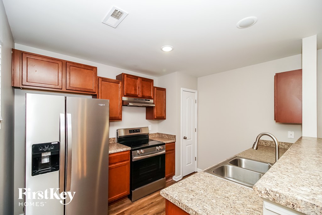 A kitchen with wooden cabinets and a granite counter top.