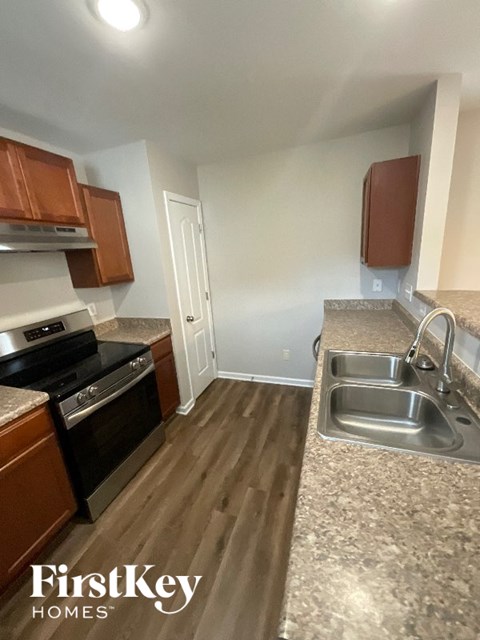 A kitchen with a sink and a stove top oven.