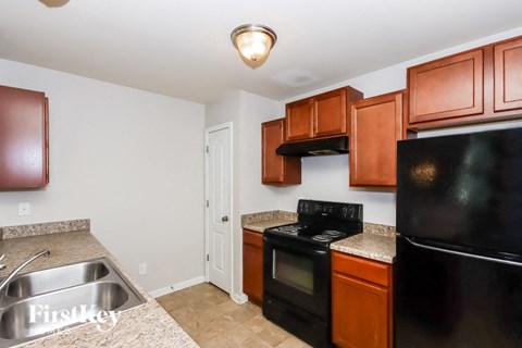 A kitchen with a black refrigerator, black oven, and black microwave.
