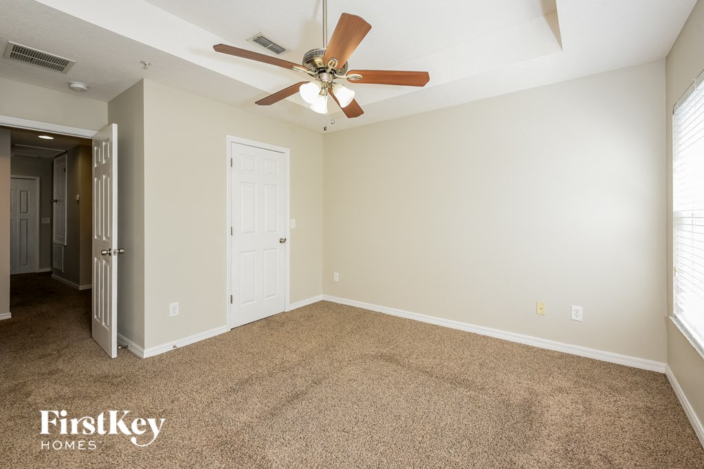 a living room with carpet and a ceiling fan