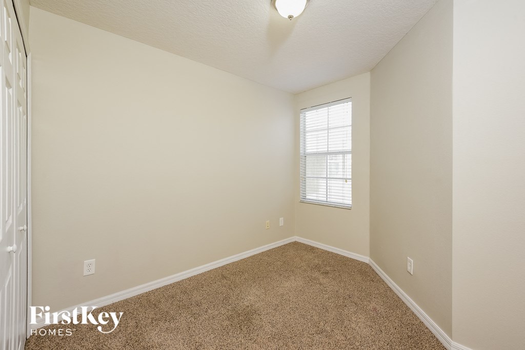 a spacious room with carpet and a window