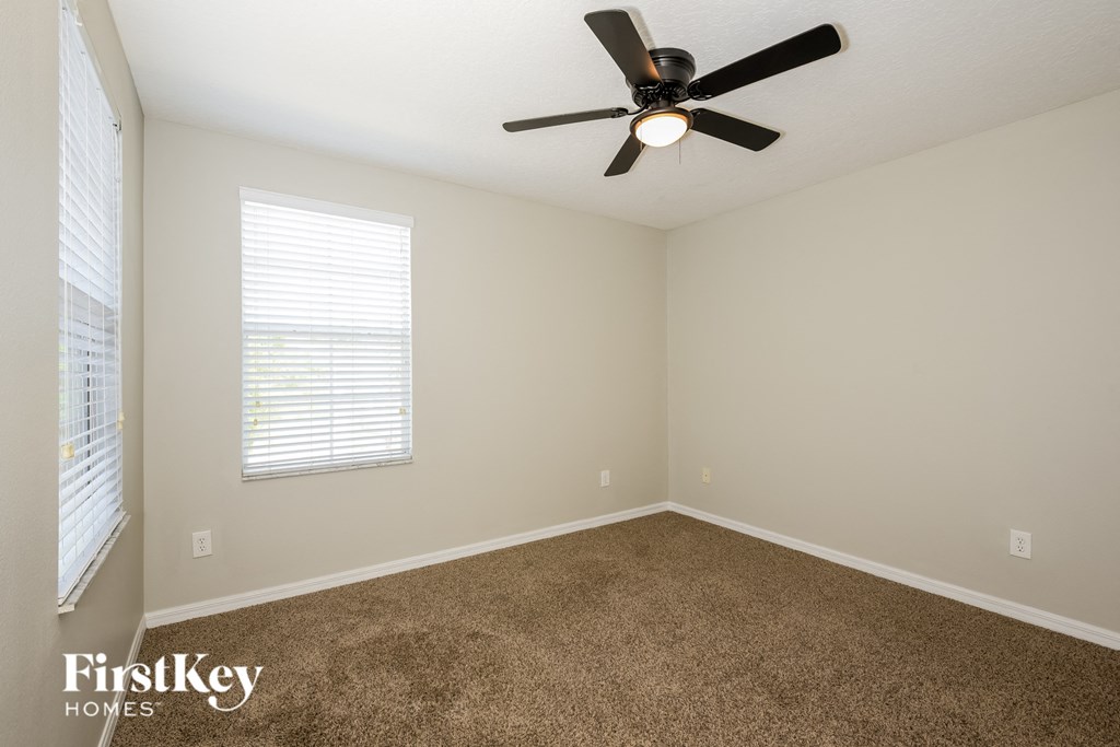 a bedroom with carpet and a ceiling fan