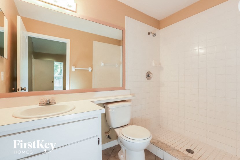 a bathroom with a toilet and a sink and a mirror