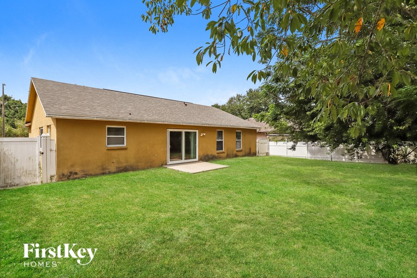 a yellow house with a yard and a tree