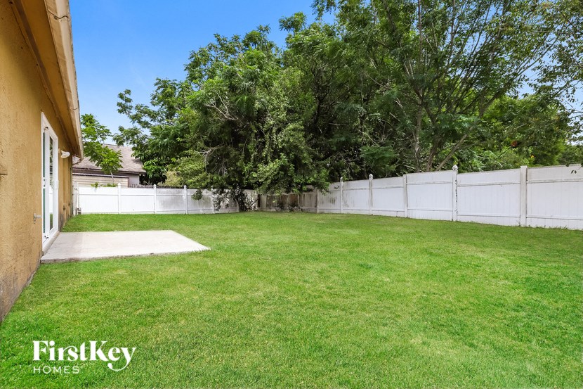a backyard with a fenced in yard and a white fence