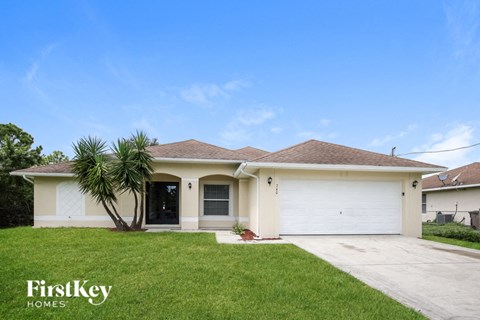 a white house with a palm tree in the yard