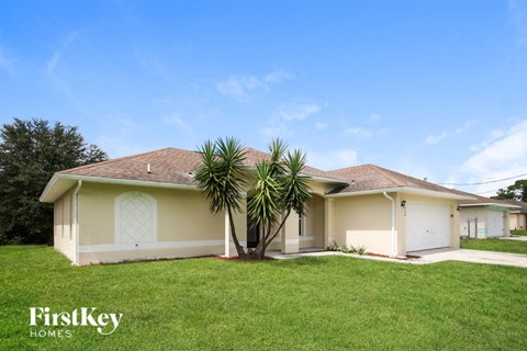 a beige house with a palm tree in the yard