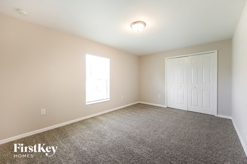 a bedroom with a carpeted floor and a white door