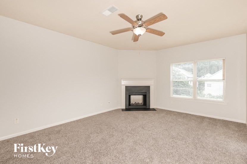 a living room with a fireplace and a ceiling fan