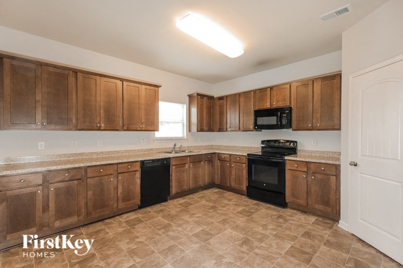 a kitchen with wooden cabinets and black appliances