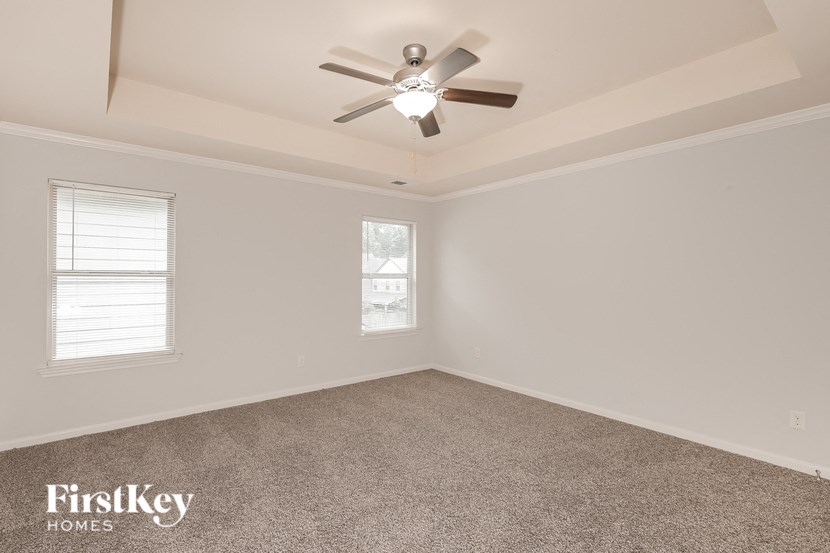 the living room of an empty home with a ceiling fan