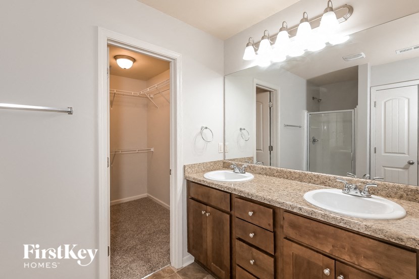 a bathroom with two sinks and a mirror and a shower