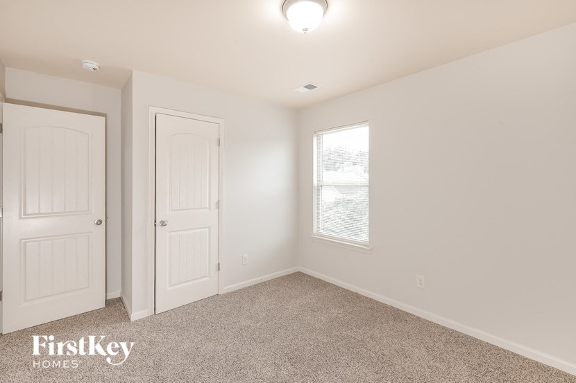 a bedroom with a white door and a window
