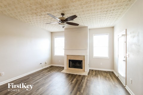 a living room with a fireplace and a ceiling fan