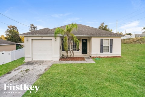 a small white house with a palm tree in the yard