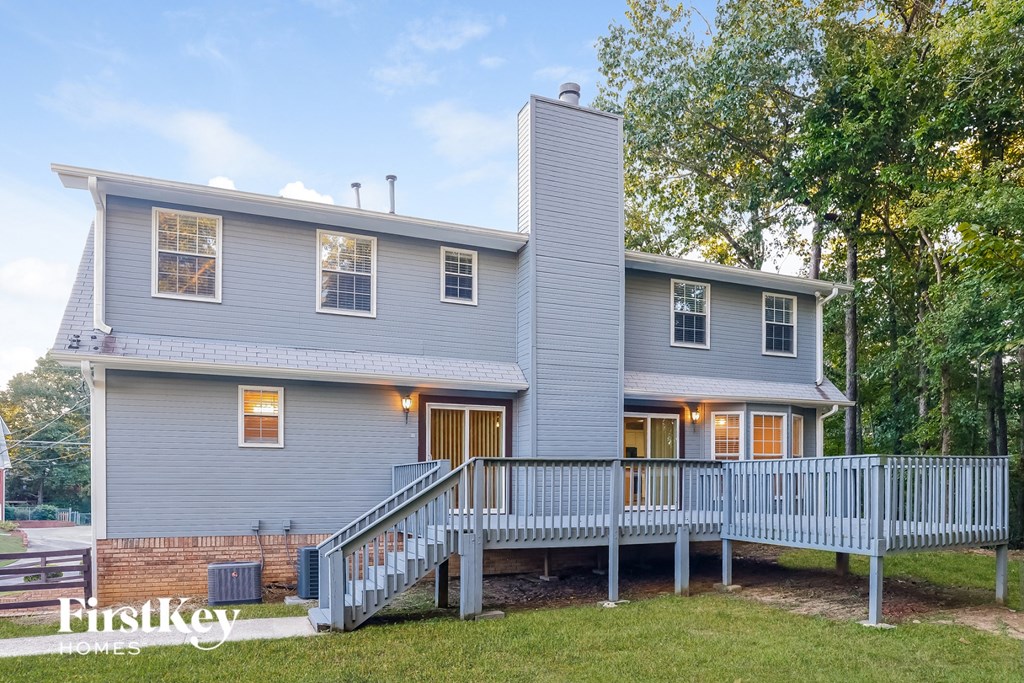 a blue house with a porch and a white deck