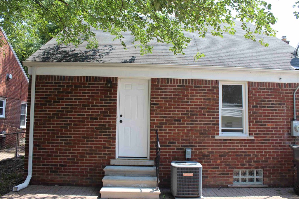 the front of a brick house with a white door