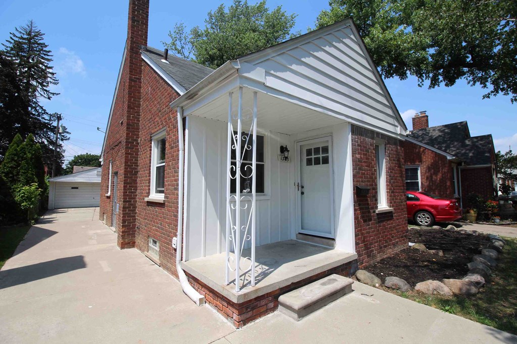 the front porch of a small red brick house