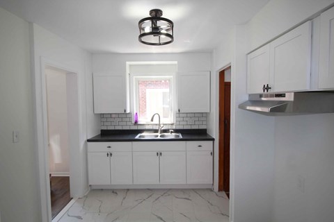 a kitchen with white cabinets and a sink