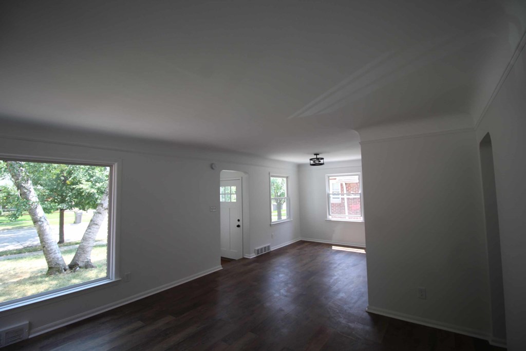 a living room with white walls and a large window