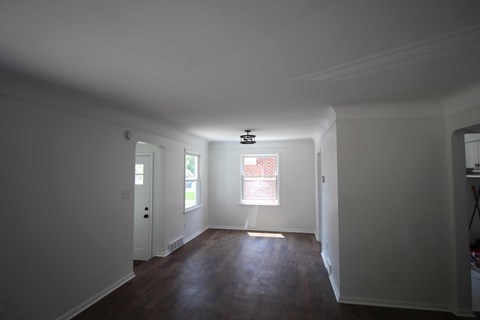 a living room with white walls and a window