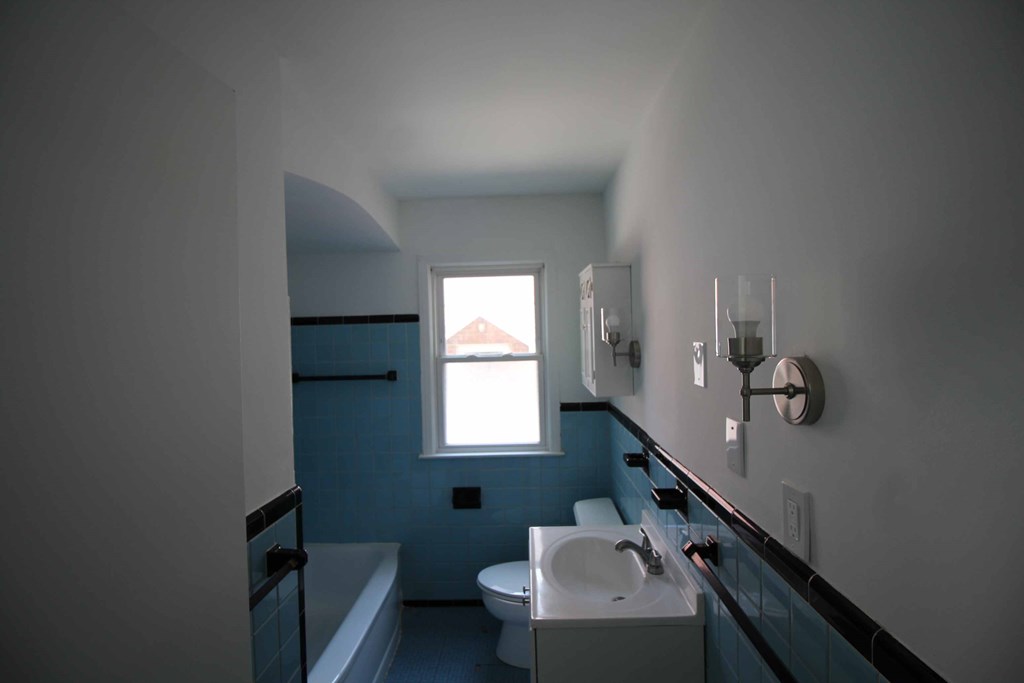 a bathroom with a sink toilet and a window