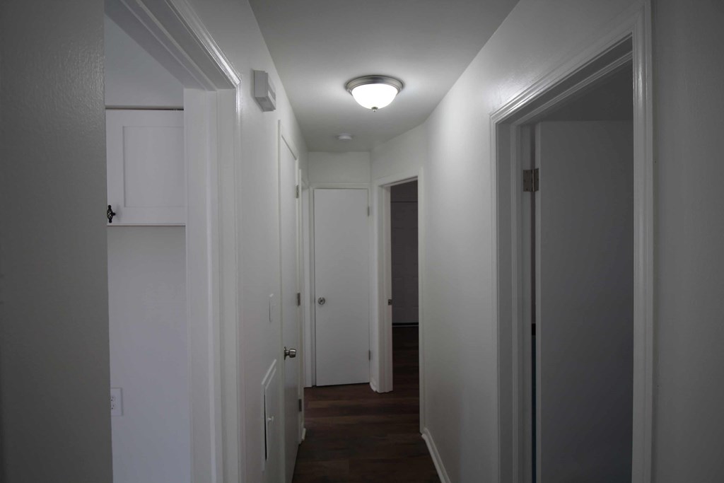 a room with a hallway and a closet and a ceiling light