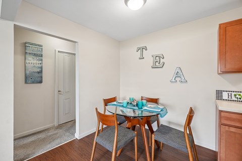 A dining room with a table set for four.