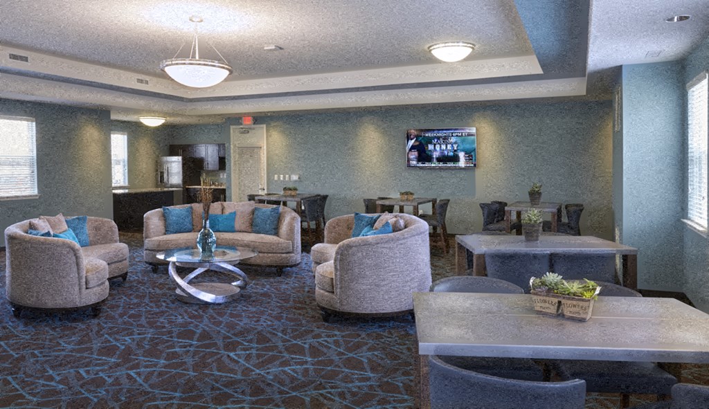 A living room with a television on the wall and a large circular table in the center.