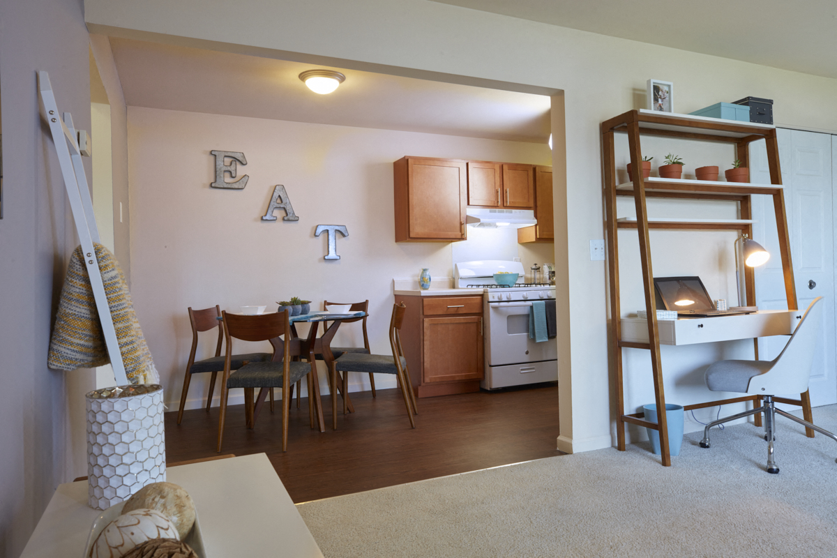 A kitchen with a dining table and chairs.