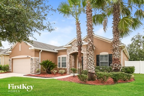 A house with palm trees in front of it.