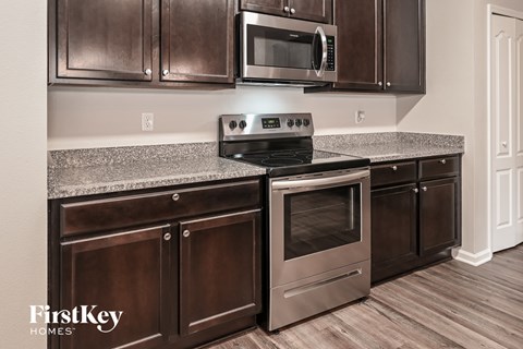A modern kitchen with a stove top oven and microwave.
