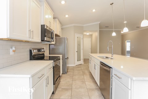 A kitchen with white cabinets and appliances.