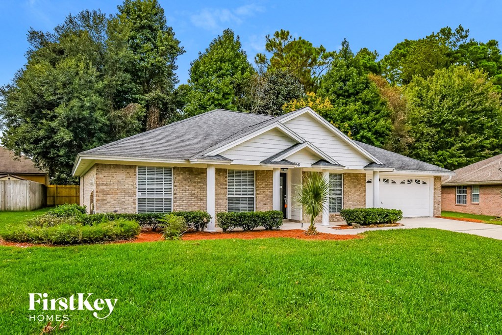 A house with a well-maintained lawn and trees in the background.