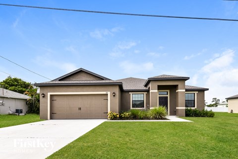a house with a garage door in front of a lawn