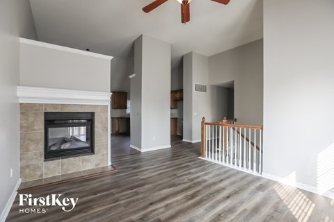 A spacious living room with a fireplace and a wooden floor.
