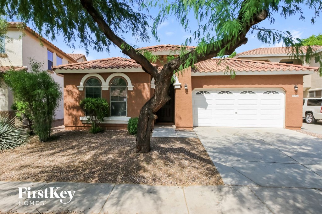 a house with a garage and a tree in front of it