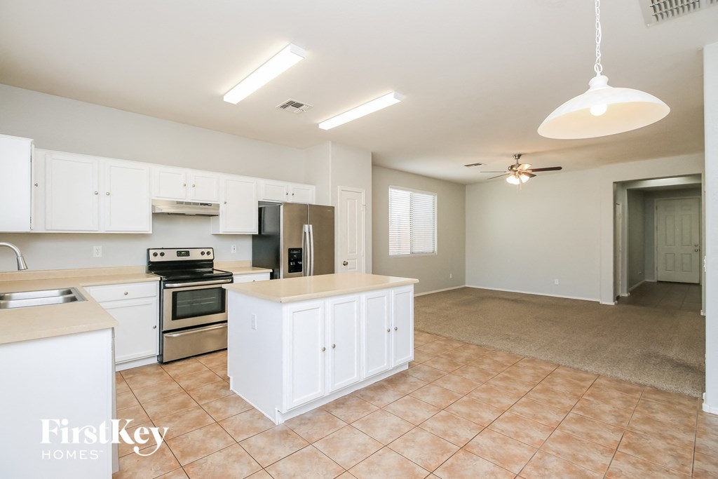 an empty kitchen with white cabinets and a counter top