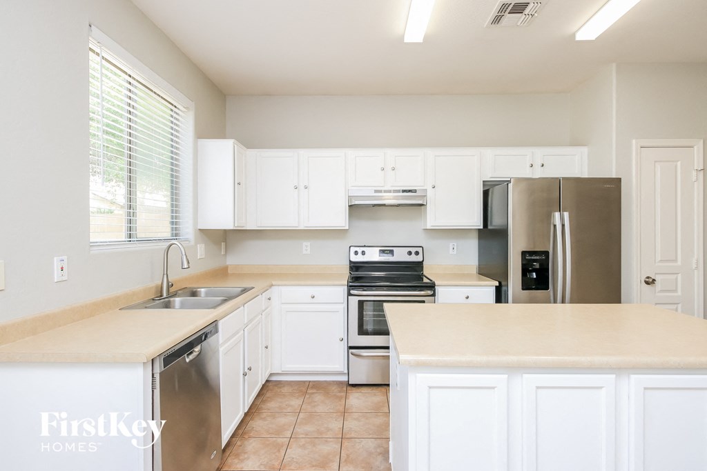 a kitchen with white cabinets and stainless steel appliances