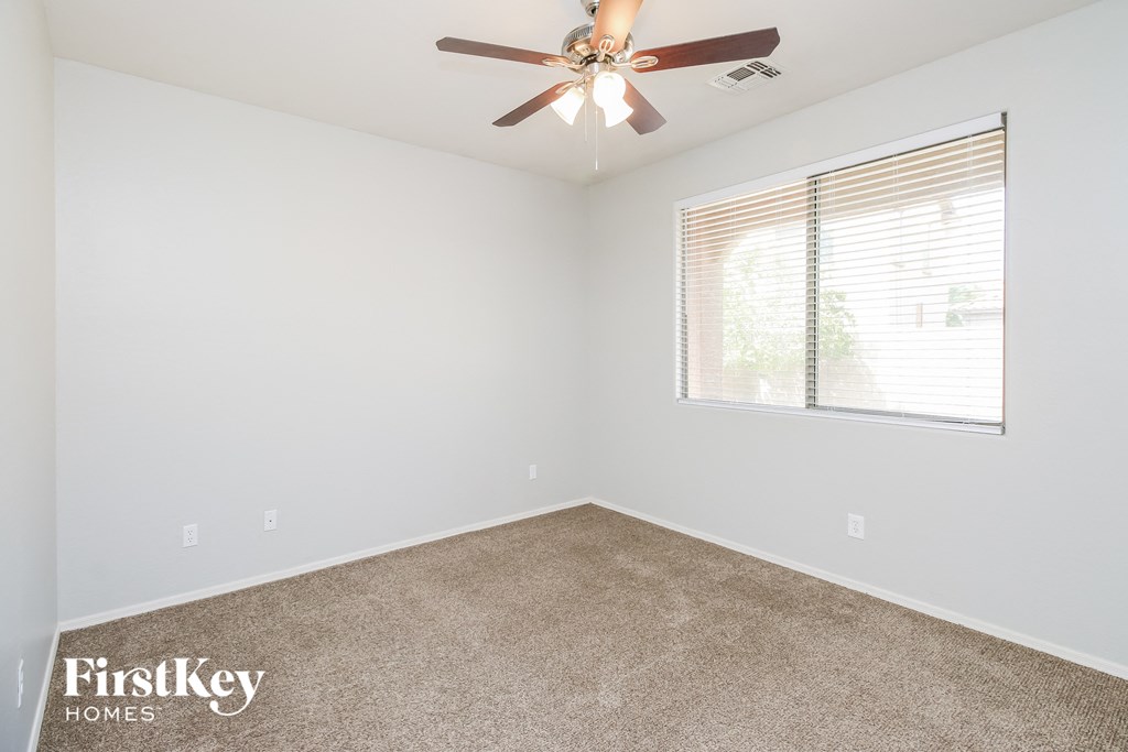 a bedroom with a ceiling fan and a window