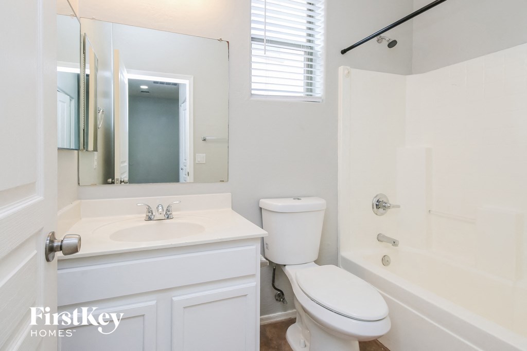 a white bathroom with a sink toilet and a shower
