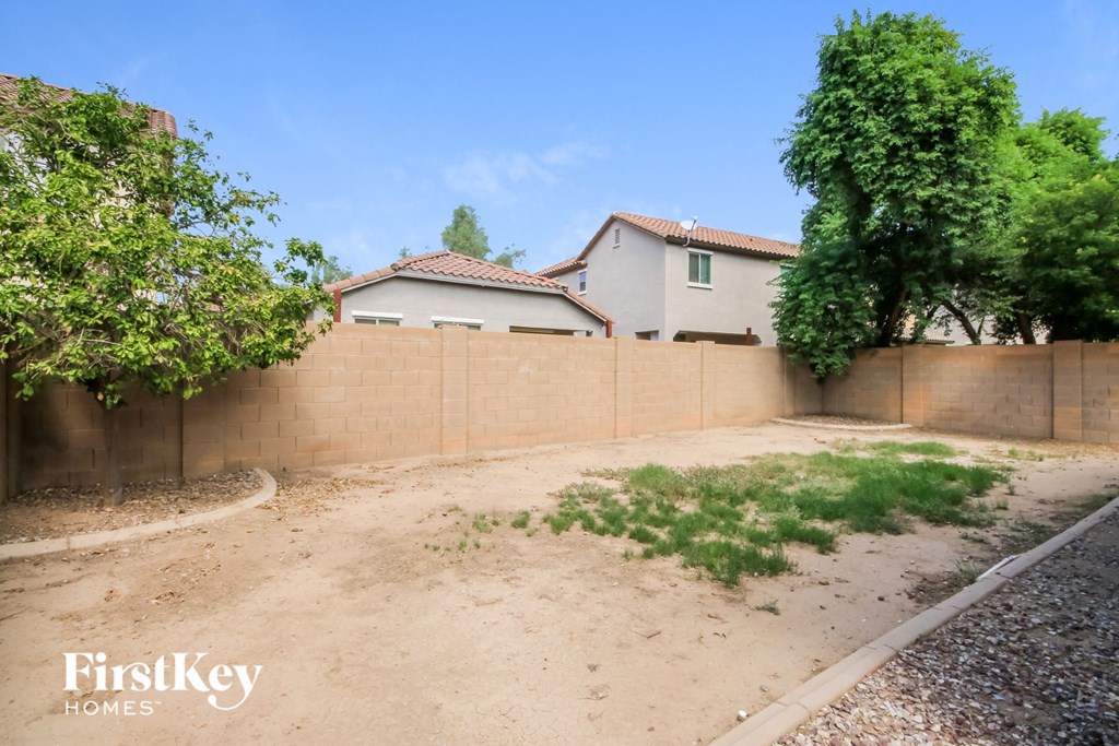 a backyard with a fence and a house