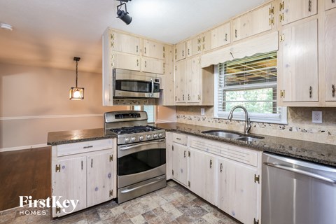 A kitchen with wooden cabinets and a checkered floor.
