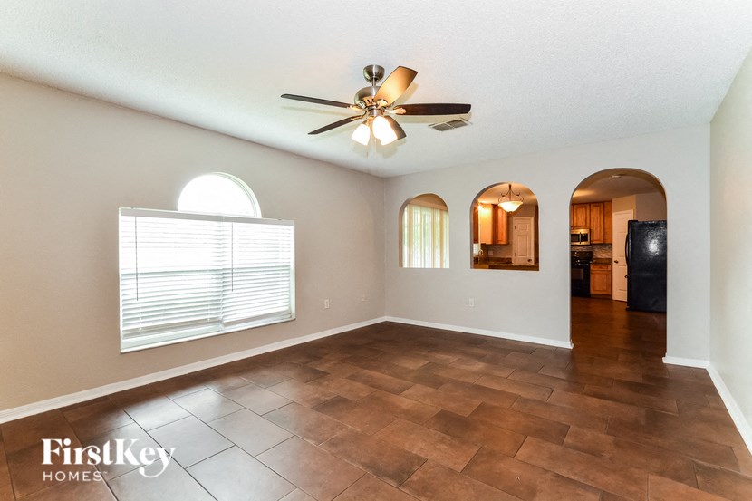a empty living room with a ceiling fan and a window